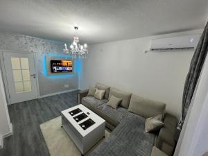 a living room with a couch and a chandelier at Apartman Bajo 1 in Foča