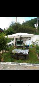 een picknicktafel met een parasol en een bank bij Casa Dirindo in Carrodano Inferiore