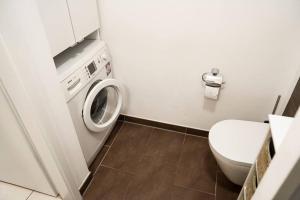 a bathroom with a washing machine and a toilet at Ferienwohnung in der Nähe von Köln in Frechen