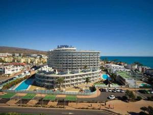 a large building with a pool in front of the ocean at Marlenghi Apartments 412 in San Bartolomé