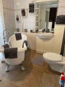 ein Badezimmer mit einer Badewanne, einem Waschbecken und einem WC in der Unterkunft Seeblick zwei im Waldschlößchen in Wendisch Rietz