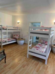 2 weiße Etagenbetten in einem Zimmer mit Holzböden in der Unterkunft Seeblick zwei im Waldschlößchen in Wendisch Rietz
