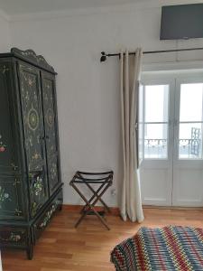 a bedroom with a green dresser and a window at Mont' Sobro House Rooms in Évora