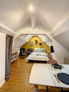duża sypialnia na poddaszu z łóżkiem i stołem w obiekcie Magnifique studio centre ville Saint Leu 2 pers w Amiens +7 zdjęć