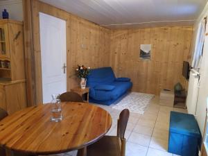 een woonkamer met een tafel en een blauwe bank bij Appartement dans un chalet de montagne in Guillestre