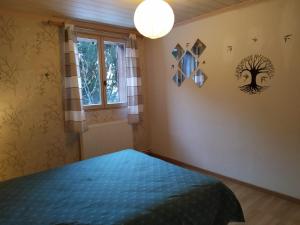 Un dormitorio con una cama azul y una ventana en Appartement dans un chalet de montagne, en Guillestre