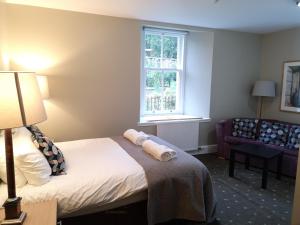 a hotel room with a bed and a couch and a window at Raasay House Hotel in Raasay