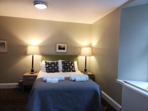 a bedroom with a bed with two towels on it at Raasay House Hotel in Raasay