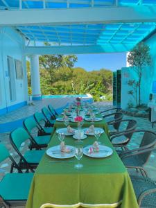 einen langen Tisch mit Tellern und Gläsern darauf in der Unterkunft Couple room in Final Destination Resort in Bolinao