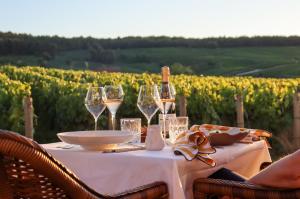 a table with glasses of wine and a vineyard at Chateau de Sacy in Sacy