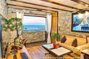 a living room with a couch and a view of the ocean at Location de charme de Thierry BOURGAIT in Banyuls-sur-Mer