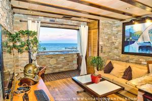 a living room with a couch and a view of the ocean at Location front de mer de Thierry Bourgait in Banyuls-sur-Mer