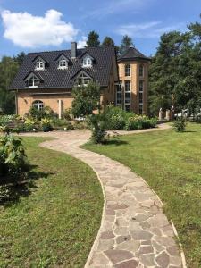 um caminho de pedra em frente a uma casa grande em Penthouse Bernd im Waldschlösschen direkt am See em Wendisch Rietz