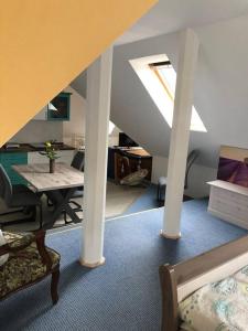 a living room with a table and a room with a ceiling at Penthouse Bernd im Waldschlösschen direkt am See in Wendisch Rietz