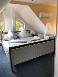 a bedroom with a large white bed with pillows at Penthouse Bernd im Waldschlösschen direkt am See in Wendisch Rietz