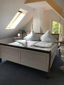 um quarto com uma cama grande com almofadas em Penthouse Bernd im Waldschlösschen direkt am See em Wendisch Rietz
