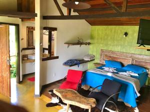 - une chambre avec un lit et deux chaises rouges dans l'établissement Chalés Vista das Montanhas, à Lavras Novas