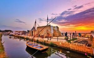 a boat in the water with a sunset in the background at Lorelai Inn in Marsala
