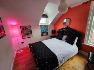 a bedroom with red walls and a bed with white sheets at Southsea Royale James Bond 3 bed Cool Penthouse, seafront parking in Portsmouth