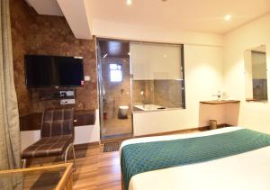 a hotel room with a bed and a television at Hotel Candor Amigo in Navi Mumbai