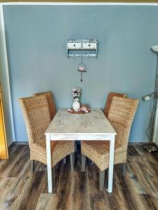a white table with two chairs and a vase on it at Strandhaus Scherko in Borkum +13 photos