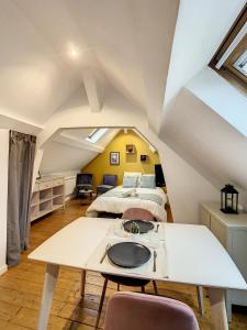 sypialnia na poddaszu z łóżkiem i stołem w obiekcie Magnifique studio centre ville Saint Leu 2 pers w Amiens