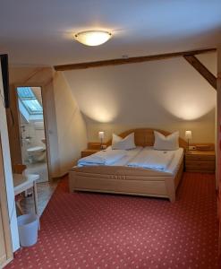a bedroom with a large bed and a bathroom at Gasthof Adler in Zusmarshausen