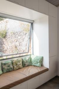 a window seat in a room with a large window at CASA DA PITANGA in Jardim do Mar