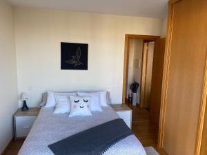 ein Schlafzimmer mit einem Bett mit zwei Katzen-Kissen darauf in der Unterkunft Green apartment in A Coruña