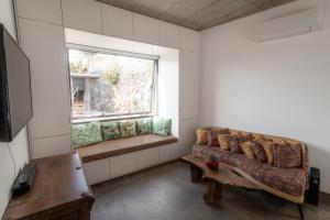 uma sala de estar com um sofá e uma janela em CASA DA PITANGA em Jardim do Mar