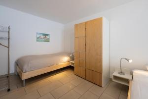a bedroom with a bed and a wooden cabinet at CASA BELLINA in Davos