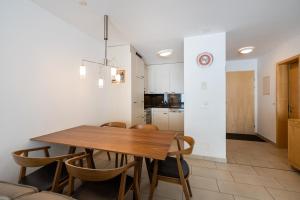 a kitchen and dining room with a wooden table and chairs at CASA BELLINA in Davos