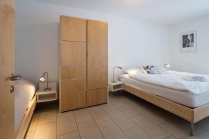 une chambre avec un lit et une armoire en bois dans l'établissement CASA BELLINA, à Davos