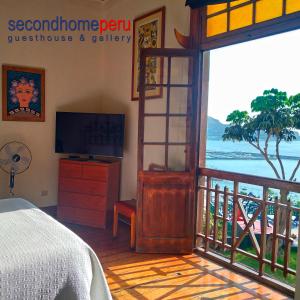 a bedroom with a bed and a balcony with a television at Second Home Peru in Lima