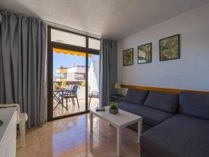 a living room with a blue couch and a table at Marlenghi Apartments 818 in San Bartolomé de Tirajana