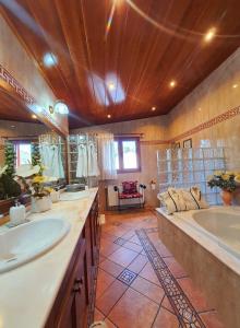 ein großes Badezimmer mit zwei Waschbecken und einer Badewanne in der Unterkunft Raco de Lis in La Torre de Claramunt