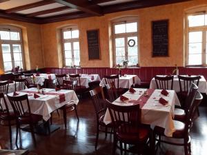 un comedor con mesas y sillas blancas y ventanas en Hotel Zum Schwanen en Leimen