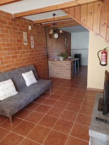 un soggiorno con divano e muro di mattoni di EL COLLAU a Llanes