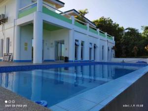 a swimming pool in front of a building at Couple room A in Final Destination Resort in Bolinao