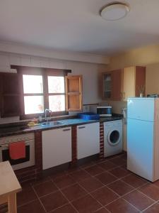 een keuken met een witte koelkast en een vaatwasser bij EL COLLAU in Llanes