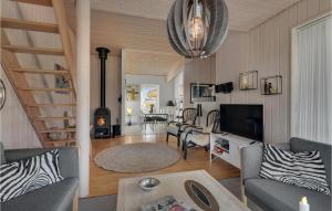 ファーボにあるNice Home In Faaborg With 3 Bedrooms, Sauna And Wifiのリビングルーム(階段付)、リビングルーム(暖炉付)