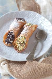 two pastries on a white plate next to a spoon at Anthony House in Villafranca Tirrena