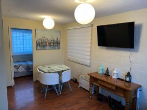 uma sala de estar com uma mesa e uma televisão na parede em Apart Hotel Chillan - Home Cozy - Empresas - Factura - Aire acondicionado em Chillán