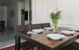 a wooden table with plates and a vase of flowers at 3 Bedroom Stunning Apartment In Nerja in Nerja