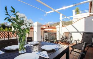 a wooden table with plates and flowers on a balcony at 3 Bedroom Stunning Apartment In Nerja in Nerja +15 photos