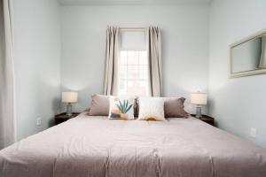 a white bedroom with a large bed with two lamps at Cacti - Cactyou - Cactus in San Antonio