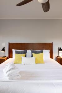 a bedroom with a white bed with yellow pillows at * Affordable Luxury Park Circle, Tres Chic! * in Charleston