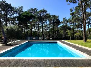 a swimming pool with blue water in a yard at Villa Colares in Sintra