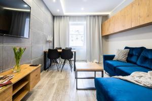 een woonkamer met een blauwe bank en een tafel bij Apartament Arena Gliwice Budget in Gliwice