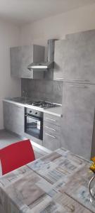uma cozinha com um fogão e uma cadeira vermelha em Casa Vacanze "O Timpune" em Petrosino